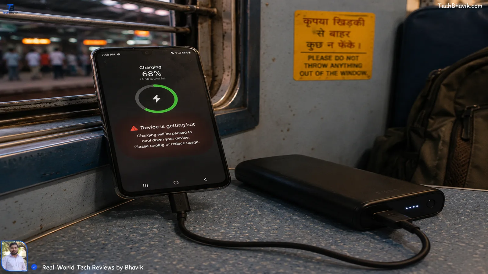 A smartphone plugged into a power bank inside an Indian train, showing heating warnings