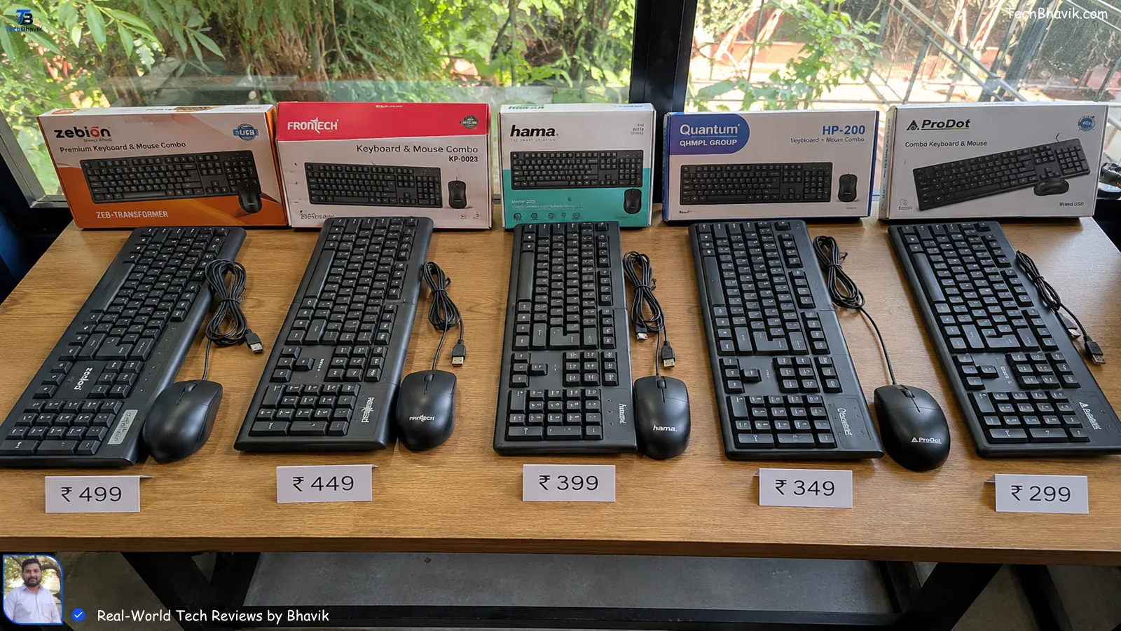Five budget keyboard mouse combos arranged on wooden table with price tags in rupees, shot in natural Ahmedabad daylight